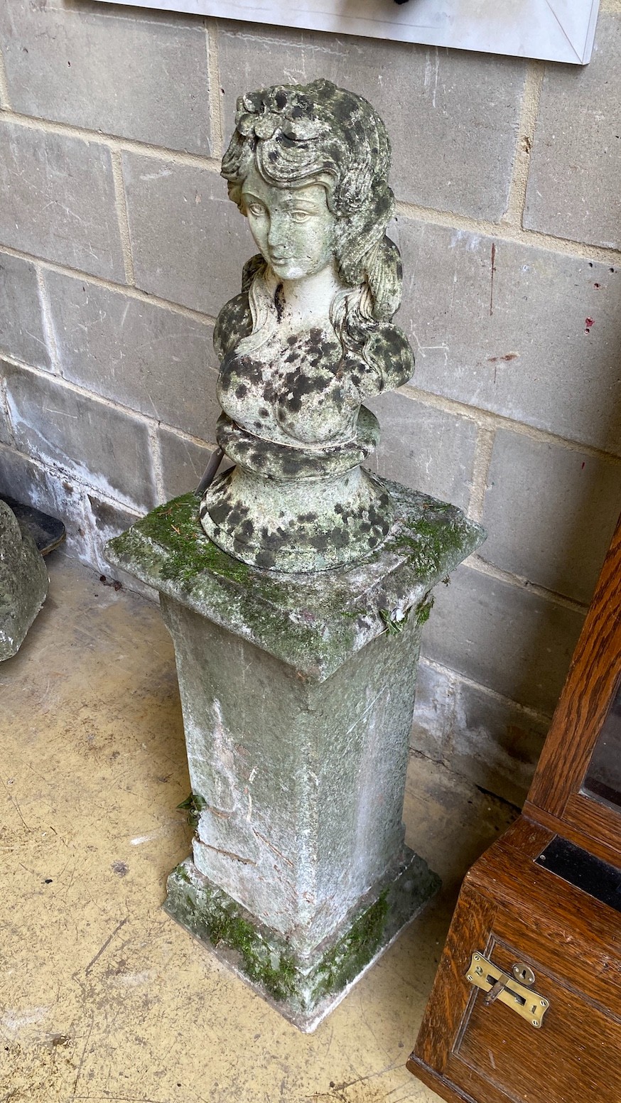 A reconstituted stone bust of a girl on a square plinth, height 112cm